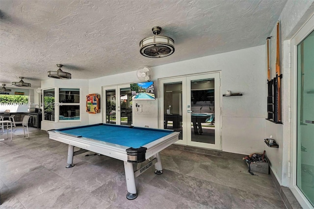 game room featuring billiards, french doors, and a textured ceiling