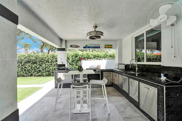 view of patio featuring grilling area, outdoor wet bar, a sink, and area for grilling
