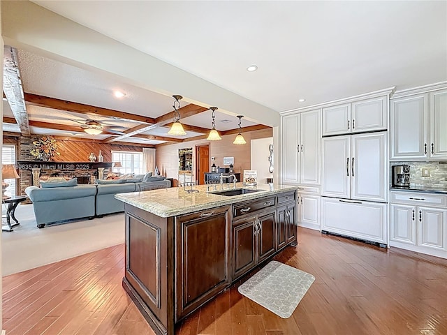 547 Deer Creek Run, Deerfield Beach, FL 33442 - kitchen with paneled built in fridge, wood-type flooring, a sink, and a center island with sink
