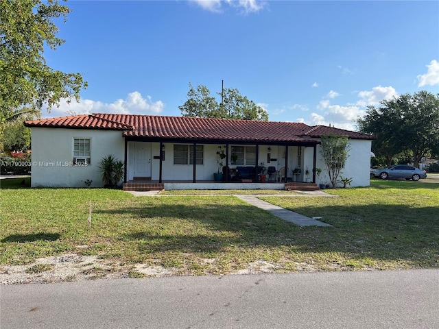 1001 NE 111th St, Biscayne Park, FL 33161 - view of front facade with a front yard, a porch, a tiled roof, and stucco siding