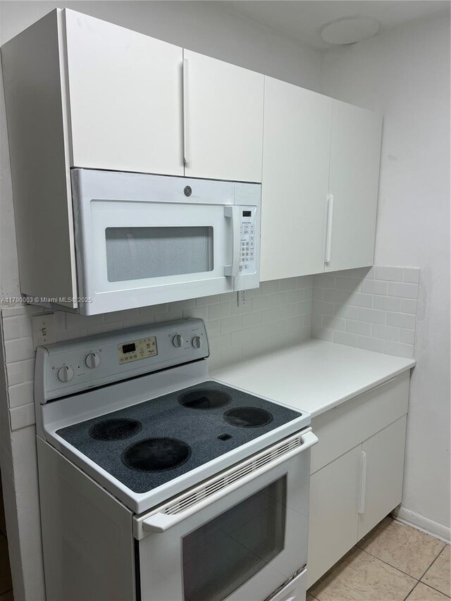 1001 NE 111th St, Biscayne Park, FL 33161 - kitchen with white cabinets, backsplash, white appliances, light countertops, and light tile patterned floors