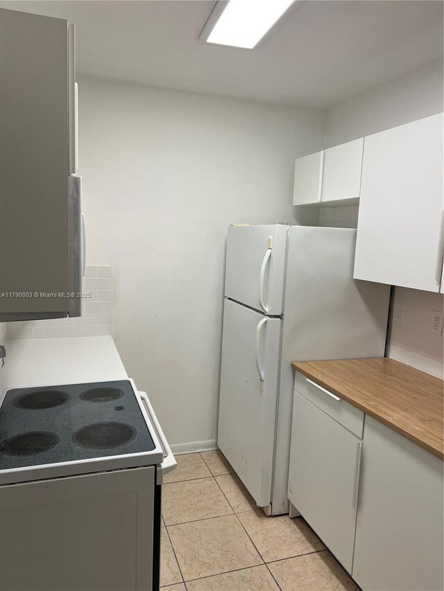 1001 NE 111th St, Biscayne Park, FL 33161 - kitchen featuring white cabinets, range with electric cooktop, tasteful backsplash, and light countertops