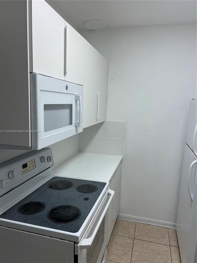 1001 NE 111th St, Biscayne Park, FL 33161 - kitchen with white cabinets, light countertops, white appliances, baseboards, and decorative backsplash