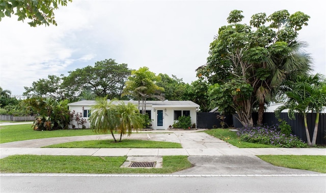 5901 NE 4th Ave, Oakland Park, FL 33334 - view of front of house with stucco siding, a front yard, fence, and curved driveway