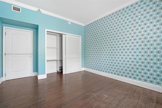 151 Crandon Blvd Unit 138, Key Biscayne, FL 33149 - unfurnished bedroom with wallpapered walls, baseboards, wood finished floors, ornamental molding, and a closet
