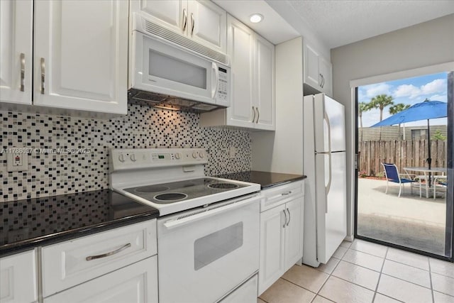 2412 24th Way, West Palm Beach, FL 33407 - kitchen featuring dark countertops, white cabinets, tasteful backsplash, and white appliances
