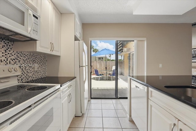 2412 24th Way, West Palm Beach, FL 33407 - kitchen with tasteful backsplash, white appliances, light tile patterned floors, white cabinets, and dark countertops