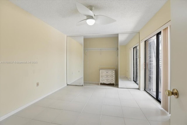 2412 24th Way, West Palm Beach, FL 33407 - unfurnished bedroom featuring light tile patterned floors, a textured ceiling, a ceiling fan, and baseboards