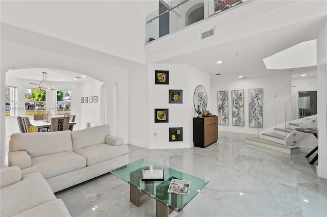 living area with arched walkways, visible vents, marble finish floor, and decorative columns