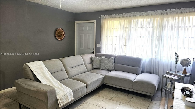 living area with a textured ceiling and light tile patterned floors