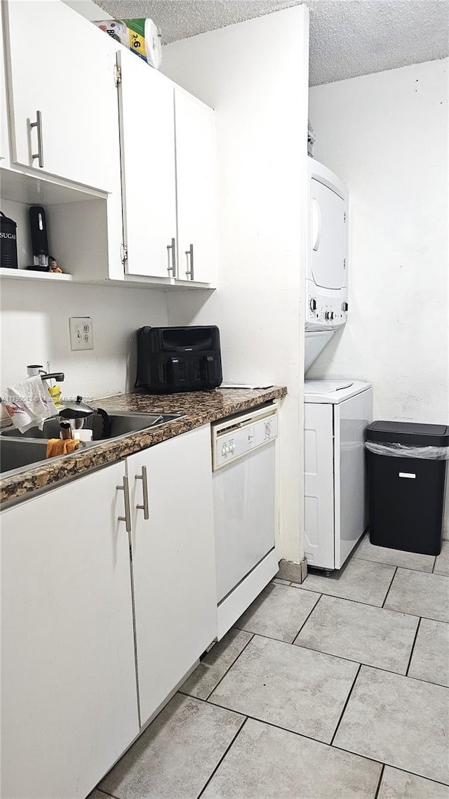 kitchen with a textured ceiling, white cabinetry, stacked washer and clothes dryer, open shelves, and dishwasher