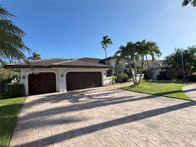 320 Windmill Palm Ave, Plantation, FL 33324 - view of front of home with decorative driveway, a garage, stucco siding, a front lawn, and a tile roof