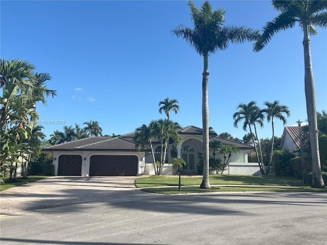 320 Windmill Palm Ave, Plantation, FL 33324 - view of front of house with an attached garage, concrete driveway, stucco siding, and a front yard