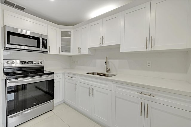 13250 SW 58th Ter Unit 10-8, Miami, FL 33183 - kitchen featuring visible vents, light tile patterned floors, a sink, appliances with stainless steel finishes, and white cabinetry