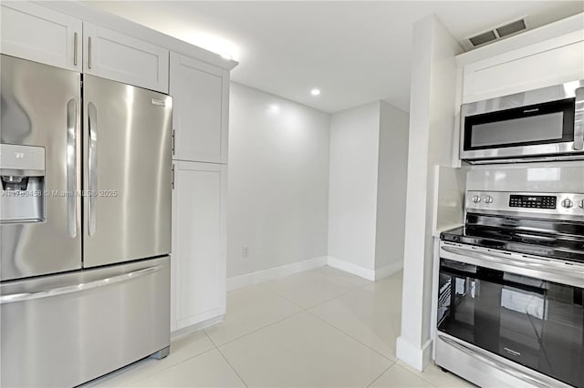 13250 SW 58th Ter Unit 10-8, Miami, FL 33183 - kitchen with stainless steel appliances, baseboards, visible vents, white cabinetry, and light tile patterned floors