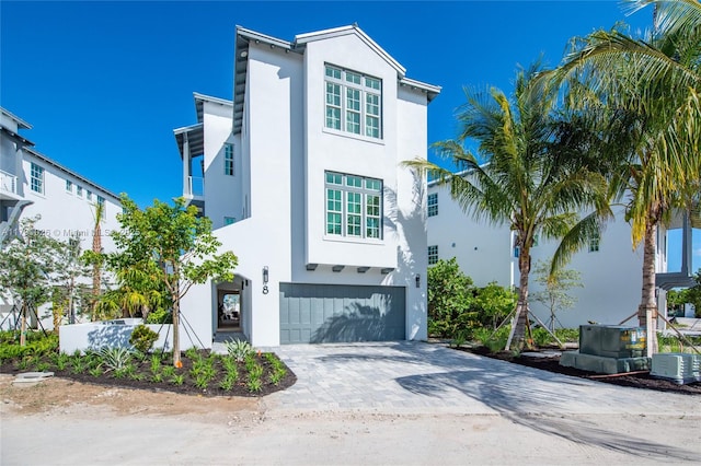 view of front of property with a garage, stucco siding, and decorative driveway