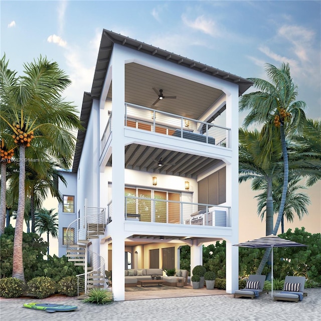 rear view of property with stairway, outdoor lounge area, a balcony, and stucco siding