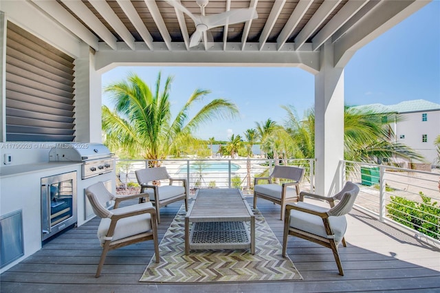 deck featuring beverage cooler, an outdoor kitchen, an outdoor hangout area, and area for grilling