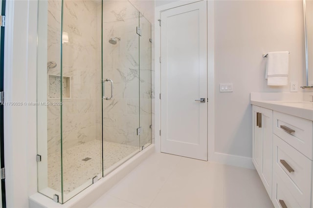 full bathroom featuring baseboards, a marble finish shower, tile patterned floors, and vanity