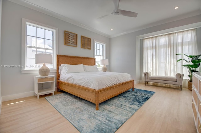 bedroom featuring a ceiling fan, baseboards, ornamental molding, and light wood-type flooring