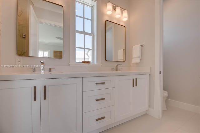 full bath with double vanity, toilet, and a sink