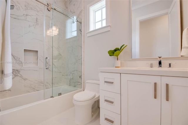 full bathroom with vanity, toilet, and shower / bath combination with glass door