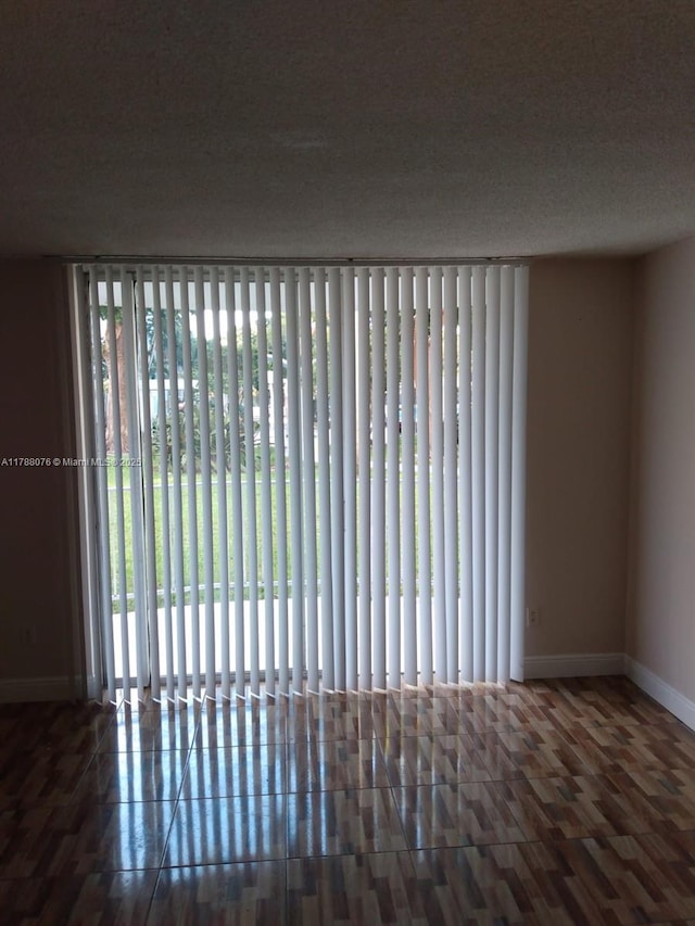 spare room featuring radiator, wood finished floors, and baseboards