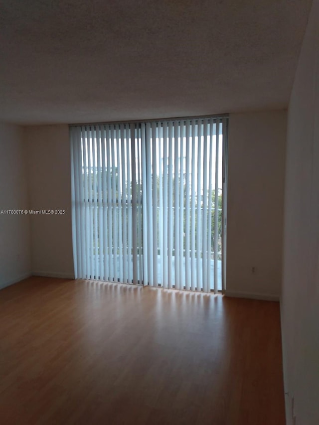 unfurnished room with wood finished floors and baseboards