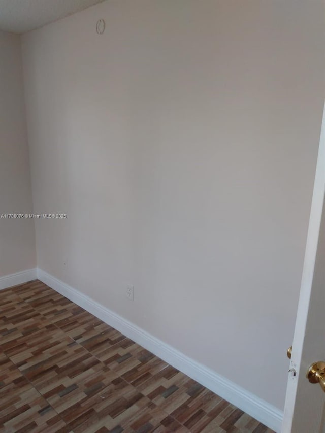 unfurnished room with wood finished floors and baseboards