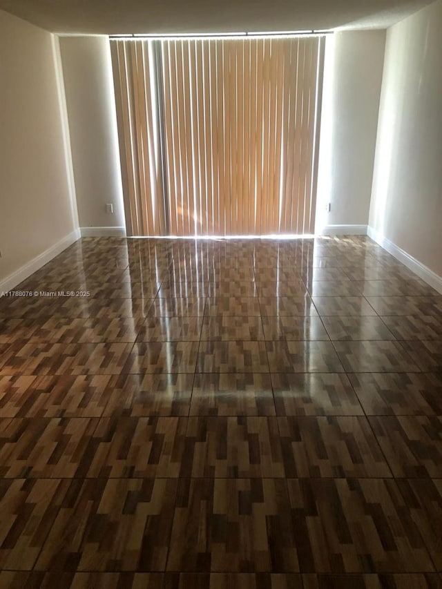 unfurnished room with baseboards