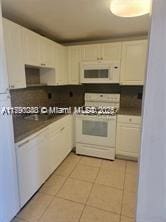 1505 Crescent Cir Unit C31, Lake Park, FL 33403 - kitchen with dark countertops, white appliances, and light tile patterned floors