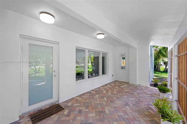 view of exterior entry featuring stucco siding and a patio