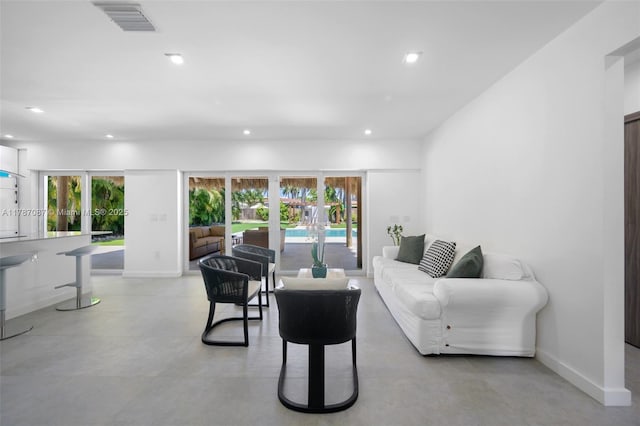 living area featuring baseboards, visible vents, recessed lighting, and finished concrete flooring