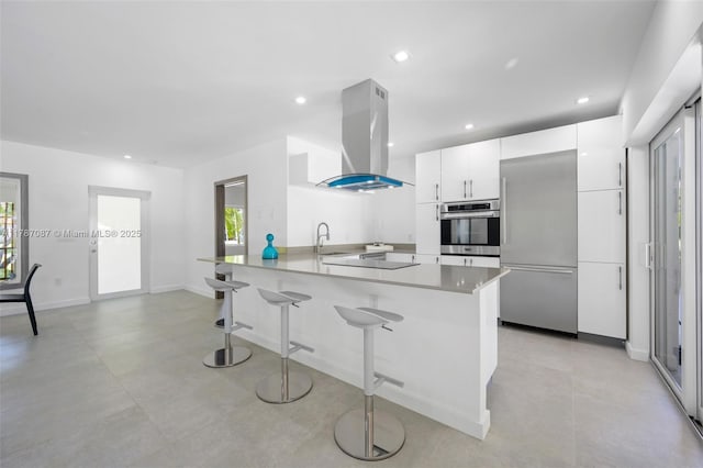 kitchen featuring stainless steel appliances, a peninsula, white cabinetry, island range hood, and modern cabinets
