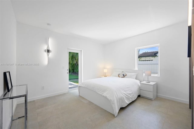 bedroom featuring baseboards and access to outside