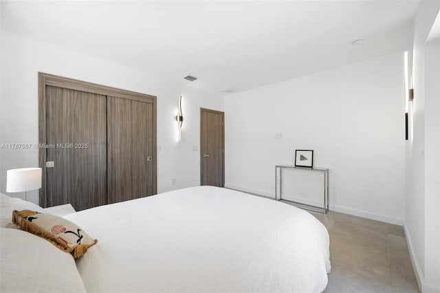 bedroom featuring baseboards, visible vents, and finished concrete flooring