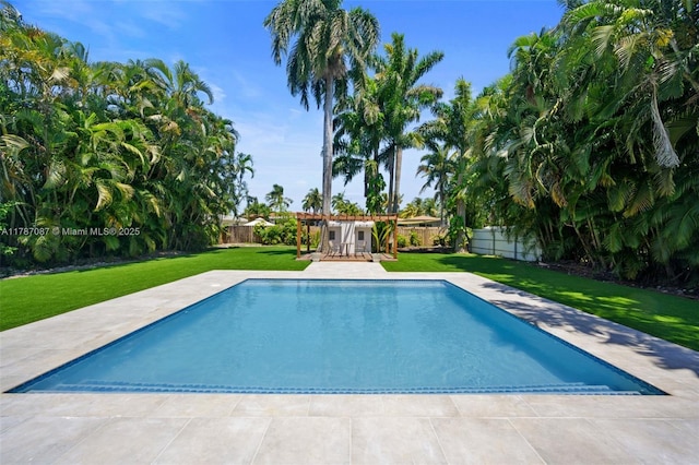outdoor pool with a fenced backyard, a patio, and a lawn
