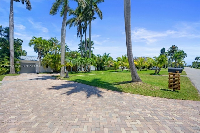 exterior space with a front lawn, decorative driveway, and a garage