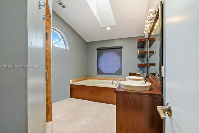 3769 NE 209th Ter, Aventura, FL 33180 - bathroom with a skylight, a garden tub, double vanity, recessed lighting, and tile patterned flooring