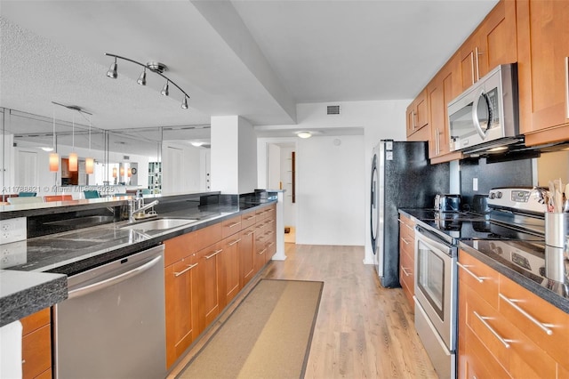 600 Parkview Dr Unit 422, Hallandale Beach, FL 33009 - kitchen with light wood-type flooring, brown cabinets, appliances with stainless steel finishes, and a sink