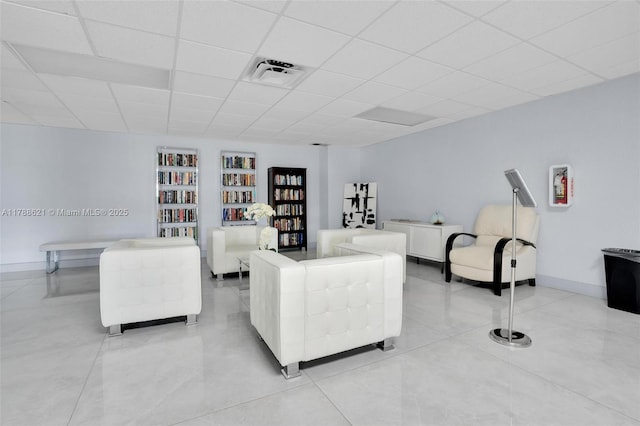 600 Parkview Dr Unit 422, Hallandale Beach, FL 33009 - living room featuring a drop ceiling, built in shelves, baseboards, visible vents, and light tile patterned flooring