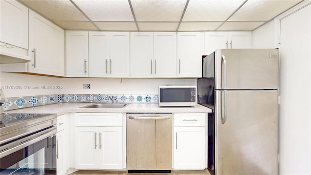8101 SW 72nd Ave Unit 304W, Miami, FL 33143 - kitchen with stainless steel appliances, a sink, a paneled ceiling, white cabinetry, and light countertops