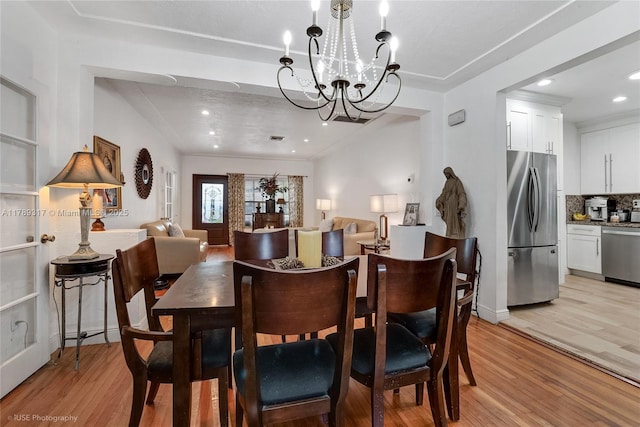 dining room featuring recessed lighting, an inviting chandelier, and light wood-style flooring