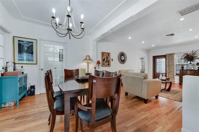 dining space with light wood finished floors, recessed lighting, visible vents, and a chandelier