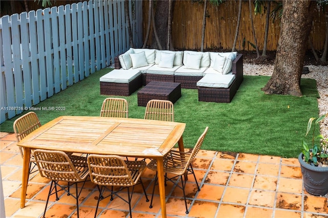 view of patio / terrace with outdoor dining space, an outdoor living space, and a fenced backyard