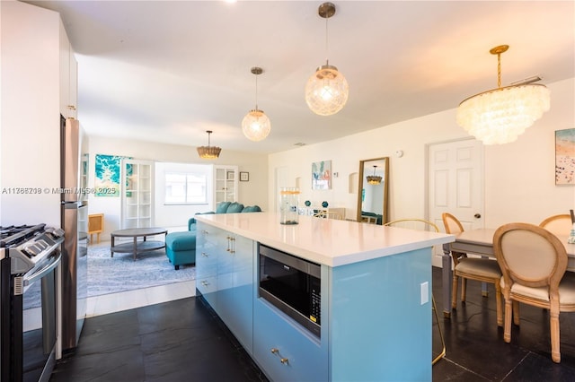 kitchen with blue cabinets, an inviting chandelier, stainless steel appliances, light countertops, and a kitchen island