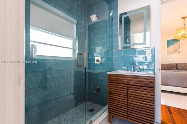 ensuite bathroom featuring a stall shower, connected bathroom, and vanity
