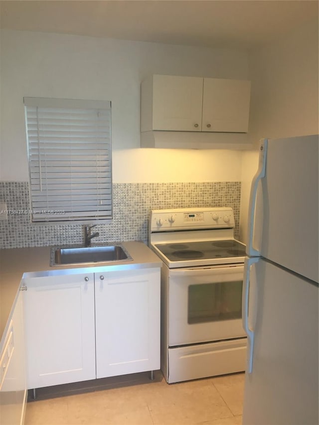 1701 Washington St Unit 503, Hollywood, FL 33020 - kitchen featuring white appliances, a sink, white cabinetry, light tile patterned floors, and tasteful backsplash