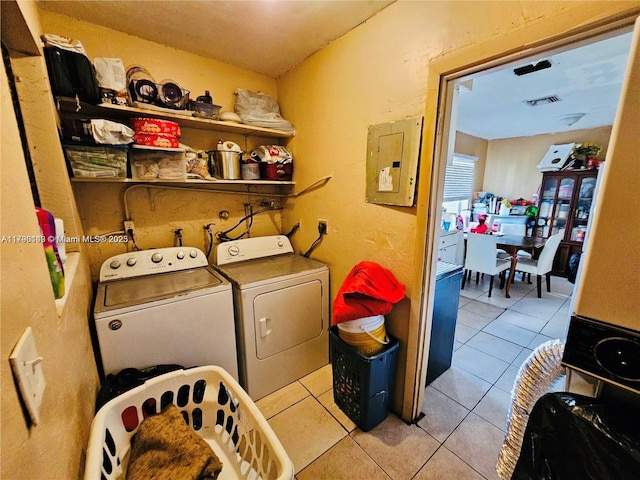 laundry area featuring light tile patterned floors, washer and dryer, electric panel, and laundry area