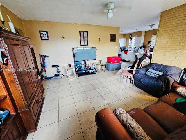 living area with light tile patterned floors and ceiling fan